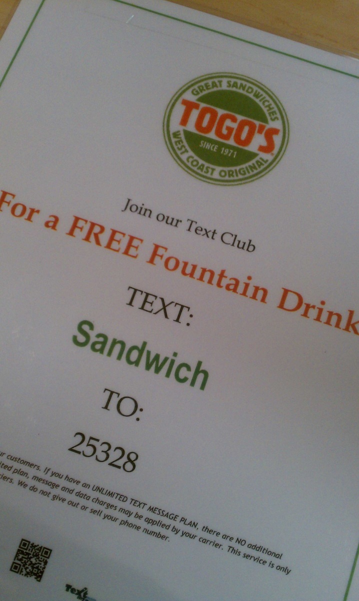 Sign showing code to text for a free drink at Togos